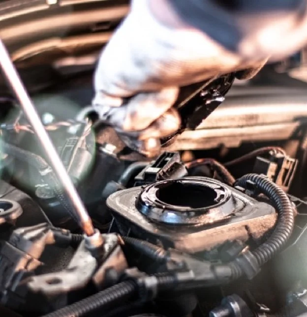 Main gantée de mécanicien travaillant sur un moteur de voiture, outils visibles à Virazeil près de Marmande dans le Lot-et-Garonne 47