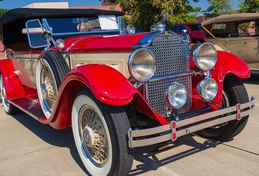 Ancienne voiture de collection rouge et crème, décapotable, avec une roue de secours latérale à Virazeil près de Marmande dans le Lot-et-Garonne 47